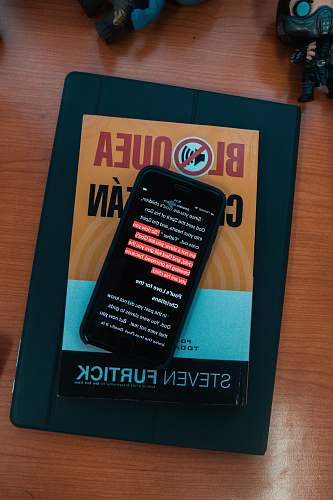 cell phone black smartphone on top of Steven Furtick book electronics